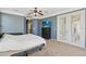 Spacious main bedroom featuring plush carpet, ceiling fan, and access to a private outdoor balcony at 318 Osprey Lakes Cir, Chuluota, FL 32766