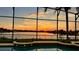 Screened-in pool area with views of a serene lake at sunset at 318 Osprey Lakes Cir, Chuluota, FL 32766