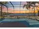 Enclosed pool with lake view at sunset at 318 Osprey Lakes Cir, Chuluota, FL 32766