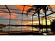Relaxing screened-in pool with an unobstructed, colorful sunset view across the lake at 318 Osprey Lakes Cir, Chuluota, FL 32766