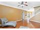 Bright sitting room with hardwood floors and stairway offers a relaxed space for reading or conversation at 318 Osprey Lakes Cir, Chuluota, FL 32766