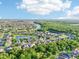 Expansive aerial view showcasing a residential community with lush landscaping and a serene lake surrounded by nature at 3514 Forest Ridge Ln, Kissimmee, FL 34741