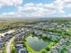 Aerial view of a community showcasing homes nestled around a lake, enveloped by lush greenery and clear skies at 3514 Forest Ridge Ln, Kissimmee, FL 34741
