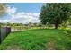 Spacious backyard with black metal fence overlooking a serene pond, perfect for relaxation at 3514 Forest Ridge Ln, Kissimmee, FL 34741