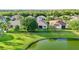 Serene backyard view with a screened lanai, green lawn, black fence, and a tranquil pond in the background at 3514 Forest Ridge Ln, Kissimmee, FL 34741