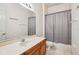 A bathroom with a large mirror, vanity and shower-tub combination with gray curtain at 3514 Forest Ridge Ln, Kissimmee, FL 34741
