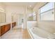 Bright primary bath featuring a soaking tub, a walk-in shower, and a large window at 3514 Forest Ridge Ln, Kissimmee, FL 34741