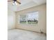 Bedroom with carpet and a ceiling fan has a large window overlooking the green landscape at 3514 Forest Ridge Ln, Kissimmee, FL 34741