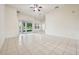Open-concept living room featuring tiled flooring, a ceiling fan, and large windows at 3514 Forest Ridge Ln, Kissimmee, FL 34741