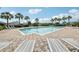 Community swimming pool with brick paver deck surrounded by lounge chairs and palm trees at 3514 Forest Ridge Ln, Kissimmee, FL 34741
