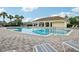 Community swimming pool with brick paver deck and a covered pavilion nearby with lounge chairs and palm trees at 3514 Forest Ridge Ln, Kissimmee, FL 34741