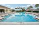 Community swimming pool with brick paver deck and a covered pavilion nearby with lounge chairs and palm trees at 3514 Forest Ridge Ln, Kissimmee, FL 34741
