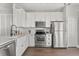 Modern kitchen featuring stainless steel appliances, white cabinets, and hardwood floors at 3912 Avalon Park West Blvd, Orlando, FL 32828