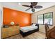 Bedroom featuring an accent wall, a ceiling fan, wood-look flooring, and a natural light window at 400 Woodview Dr, Longwood, FL 32779