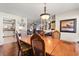 An inviting dining room with dark wood floors, a wooden table, and a view into the living area at 400 Woodview Dr, Longwood, FL 32779