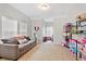 Bright bonus room features neutral carpet, grey sofa, and shelves for storage at 4094 Oak St, Orlando, FL 32814