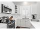 Close-up of kitchen area with stainless steel appliances, white cabinets, and subway tile at 4094 Oak St, Orlando, FL 32814