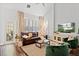 Bright living room featuring a leather sofa, neutral tones, and large windows with plantation shutters at 4094 Oak St, Orlando, FL 32814