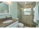 Modern bathroom with a tiled glass shower, granite countertop vanity, and decorative mirror at 411 Hibiscus Rd, Casselberry, FL 32707
