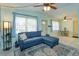 Bright living room featuring a cozy blue sectional sofa and large windows with natural light at 411 Hibiscus Rd, Casselberry, FL 32707