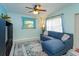 Inviting living room showcasing tile flooring, a blue sectional sofa, and a ceiling fan at 411 Hibiscus Rd, Casselberry, FL 32707