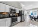 Modern kitchen with stainless steel appliances, white cabinetry, a decorative backsplash, and a dining area at 485 Sandpiper Ridge Dr, Orlando, FL 32835