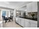 Eat-in kitchen featuring white cabinets, stainless steel appliances, dark countertops, and ample natural light at 485 Sandpiper Ridge Dr, Orlando, FL 32835