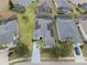 Aerial view of a home with solar panels, surrounded by lush green lawns and neighboring houses at 506 Pineloch Dr, Haines City, FL 33844