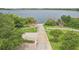 Wide driveway leads to a serene lakefront property, surrounded by lush greenery and mature trees at 506 Pineloch Dr, Haines City, FL 33844