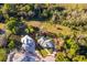 Aerial view showing a lovely landscaped home with a circular drive and mature trees at 516 Sanctuary Golf Pl, Apopka, FL 32712