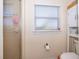 Bright bathroom featuring a glass-enclosed shower, window with blinds, and storage cabinet at 516 Sanctuary Golf Pl, Apopka, FL 32712