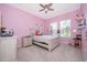 Bright pink bedroom with plenty of natural light, ceiling fan, and a comfortable bed at 516 Sanctuary Golf Pl, Apopka, FL 32712