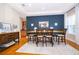 Dining room with wood floors, a blue accent wall, and a large dining table with seating at 516 Sanctuary Golf Pl, Apopka, FL 32712