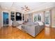Open-concept living room with a gray sectional sofa, ceiling fan, and built-in shelving at 516 Sanctuary Golf Pl, Apopka, FL 32712