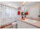 This bathroom features a single sink vanity, tropical themed shower curtain, and neutral colored walls at 5300 S Atlantic Ave # 2-501, New Smyrna Beach, FL 32169
