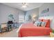 Cozy bedroom featuring blue walls, a desk, and a queen bed with bright orange bedding at 5300 S Atlantic Ave # 2-501, New Smyrna Beach, FL 32169