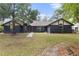 Charming home featuring a striking black exterior, a well-manicured lawn, and mature trees at 5340 Jones Rd, St Cloud, FL 34771