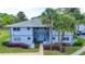 Charming two-story condo with tropical landscaping and exterior stairs leading to the second floor entrance at 576 Fairways Ln # M103, Ocala, FL 34472