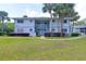 Inviting two-story condo with lush green lawn, mature landscaping, and an open staircase leading to upper units at 576 Fairways Ln # M103, Ocala, FL 34472