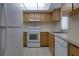 A clean kitchen with a white refrigerator, oven, dishwasher, and light wood cabinets at 576 Fairways Ln # M103, Ocala, FL 34472