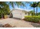 Home exterior featuring a garage, brick driveway, landscaping, and light paint at 600 Brechin Dr, Winter Park, FL 32792