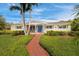 Charming single-story home with a well-manicured front yard, mature landscaping and a brick walkway leading to the front door at 600 Brechin Dr, Winter Park, FL 32792