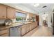 Well-lit kitchen with granite countertops, stainless steel appliances, wood cabinets, and a view into the dining room at 600 Brechin Dr, Winter Park, FL 32792