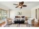 Bright living room with hardwood floors, a ceiling fan, neutral decor, and ample natural light from a large window at 600 Brechin Dr, Winter Park, FL 32792