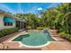 Stunning pool area surrounded by lush landscaping and a brick paver deck, perfect for outdoor entertaining and relaxation at 600 Brechin Dr, Winter Park, FL 32792