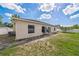 The backyard featuring the home's exterior with air conditioner unit and partial grass coverage at 62 York Ct, Kissimmee, FL 34758
