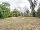 View of the home's backyard with mature trees surrounding the perimeter at 633 Hermits Trail, Altamonte Springs, FL 32701