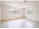 Bright, tiled bedroom featuring two large windows that provide ample natural light and a ceiling fan for comfort at 633 Hermits Trail, Altamonte Springs, FL 32701