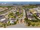 Aerial view of a community featuring tree-lined streets, a community center with a pool, and a lake in the background at 8109 Ludington Cir, Orlando, FL 32836