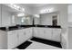 Spacious bathroom features double sinks, a dark countertop, lots of cabinet space, and large mirrors at 8109 Ludington Cir, Orlando, FL 32836